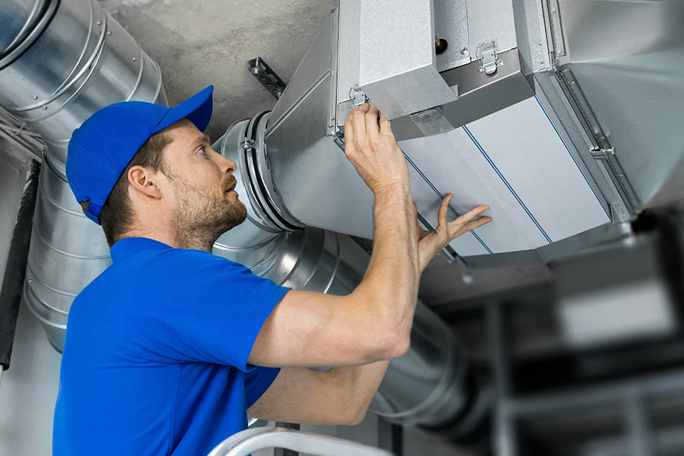 HVAC technician inspecting ventilation system