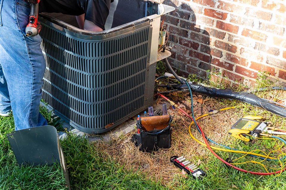 HVAC technician performing heat pump replacement service