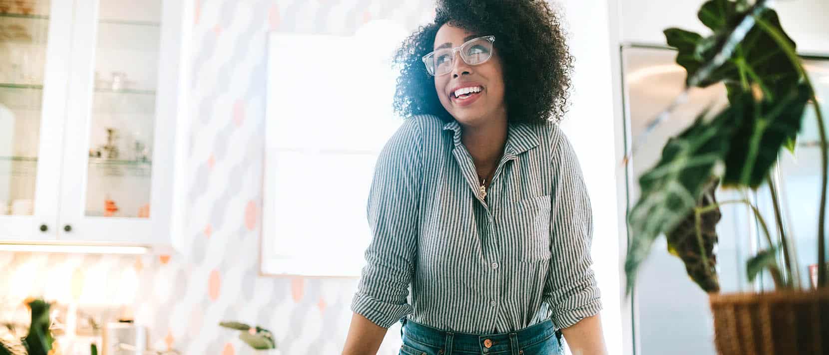 woman in the kitchen smiling and looking into the distance